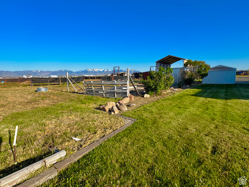 View of yard featuring a mountain view and fence