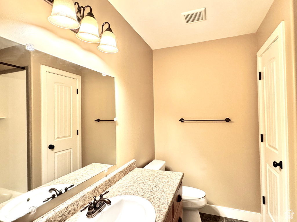 Bathroom with toilet, visible vents, baseboards, tile patterned flooring, and vanity