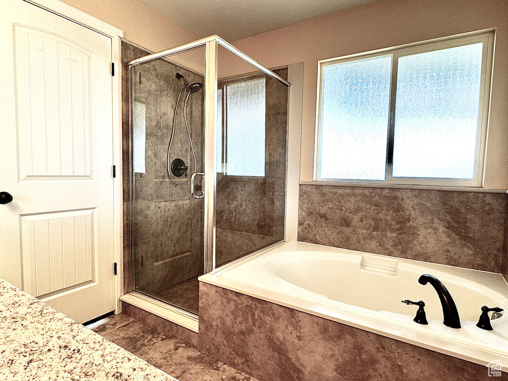 Bathroom featuring a garden tub and a shower stall