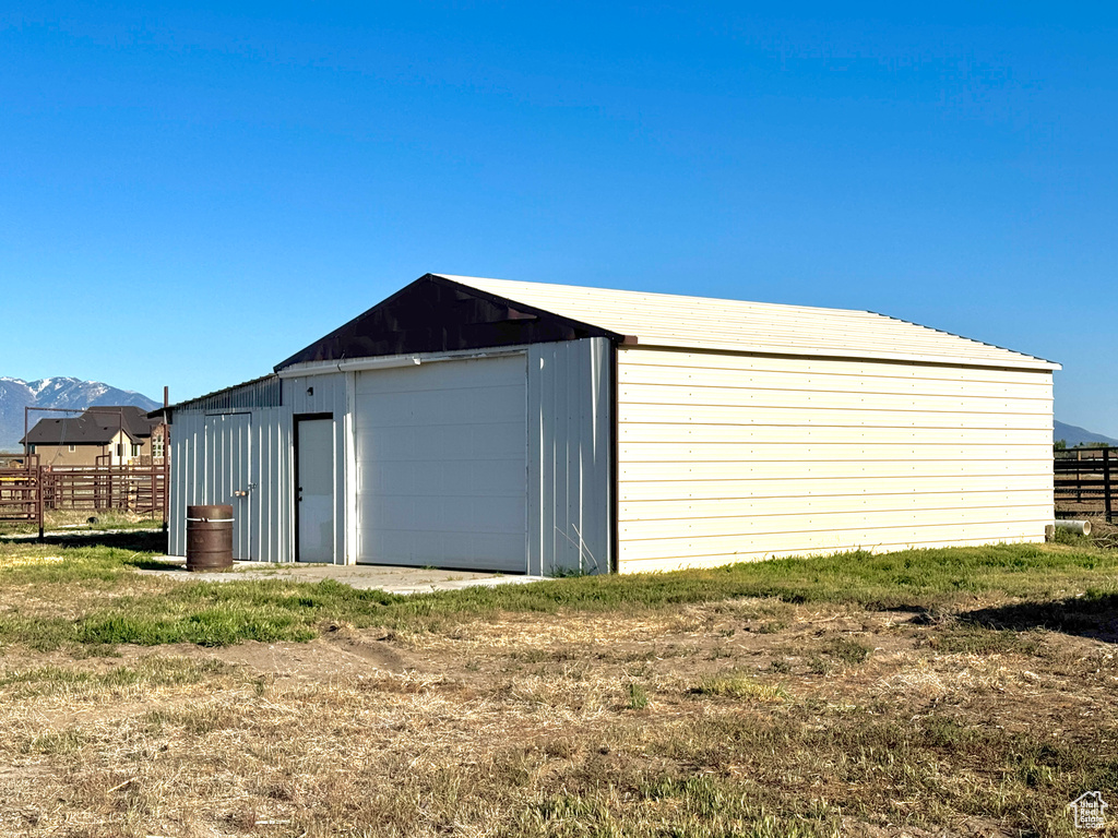 Detached garage with fence and a mountain view