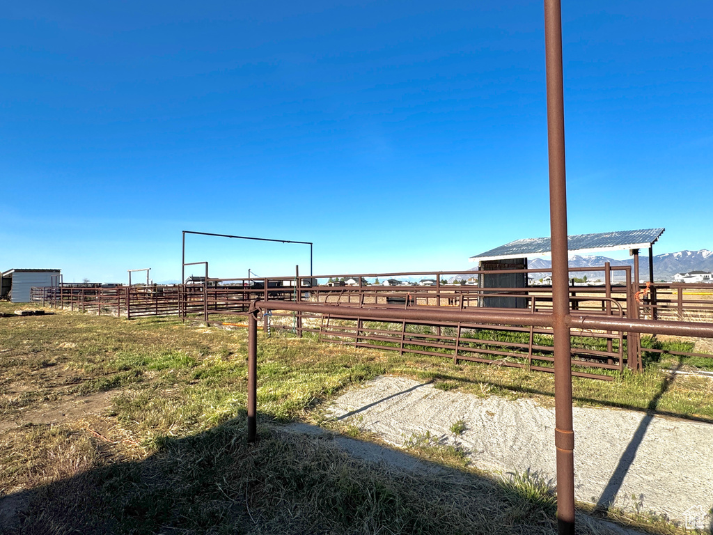 View of yard with a rural view, an outdoor structure, and an exterior structure