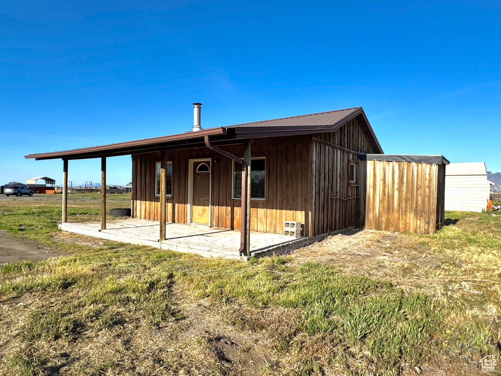 Rear view of property with a patio area and board and batten siding