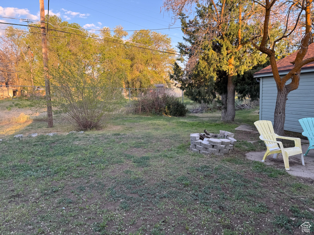 View of yard with fence and an outdoor fire pit