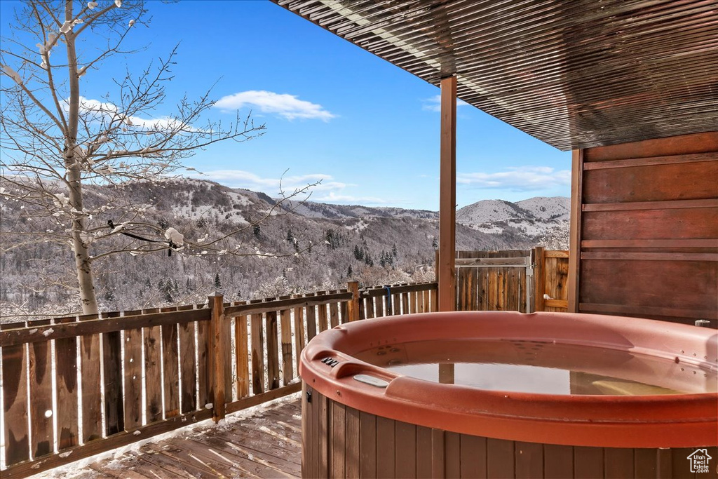 Deck featuring a hot tub and a mountain view
