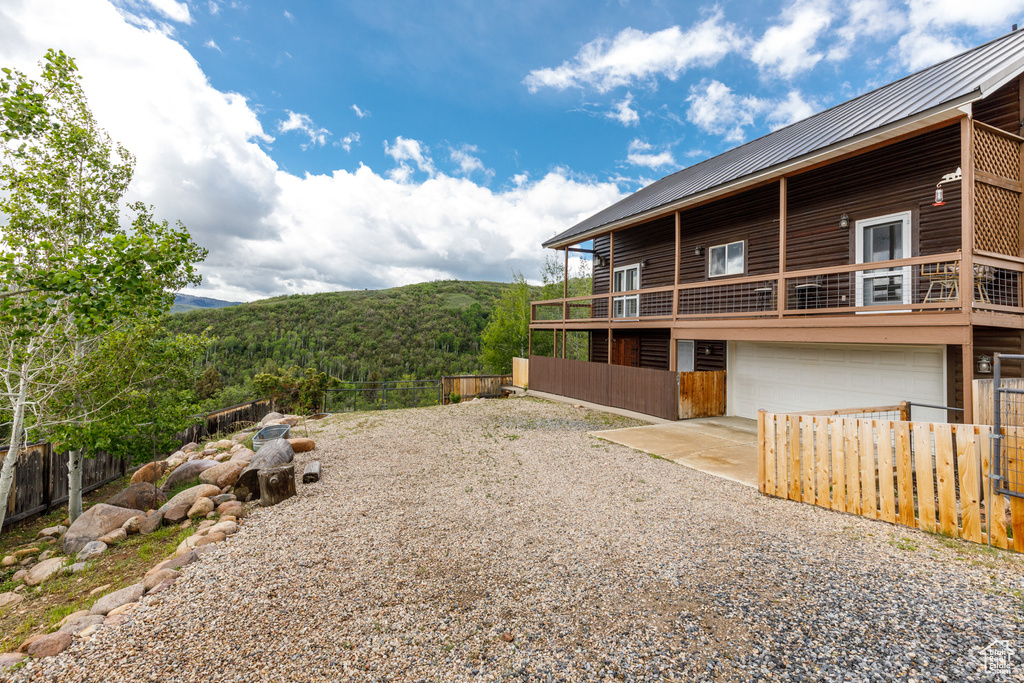 View of home\'s exterior featuring gravel driveway, a garage, a mountain view, and metal roof