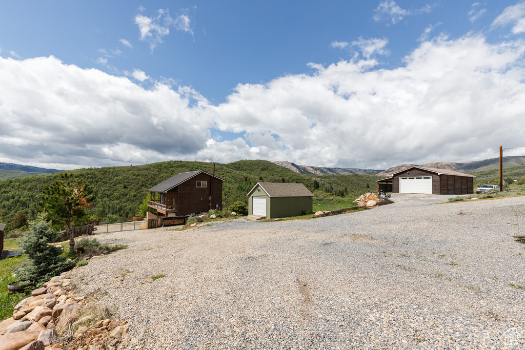 View of outbuilding with a mountain view and gravel driveway