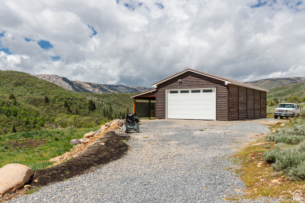 Garage with a mountain view and gravel driveway