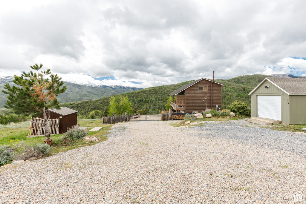 View of yard featuring a mountain view, an outbuilding, and a garage