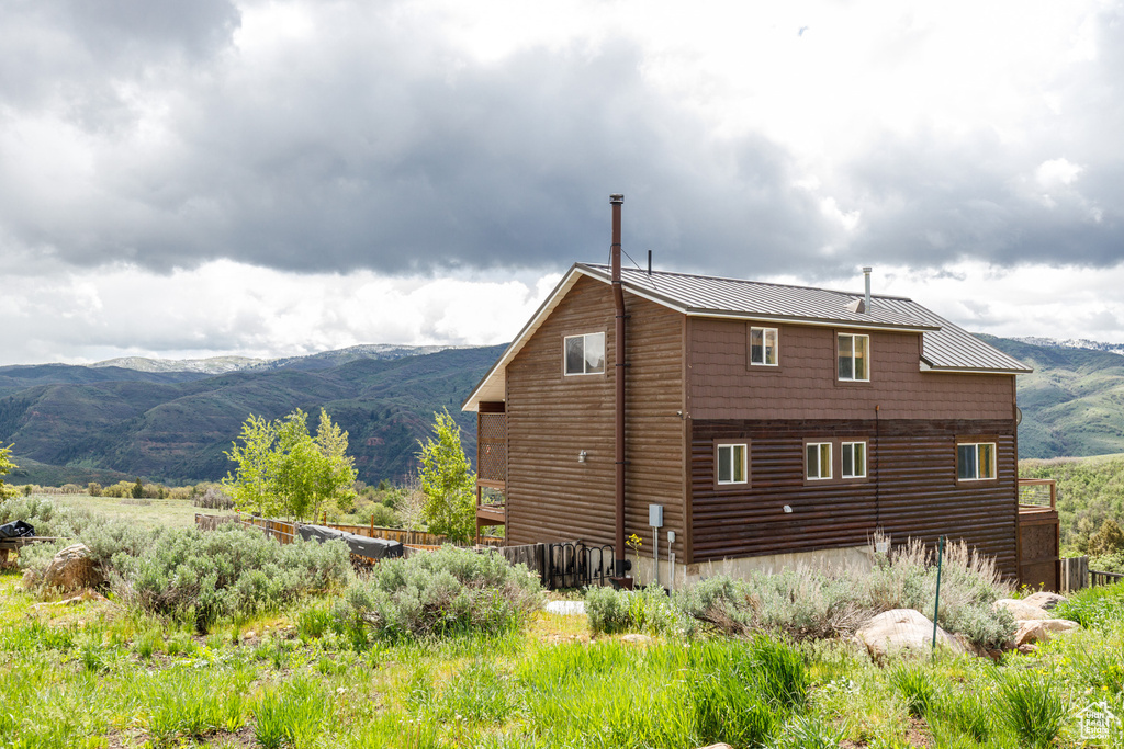 Back of property featuring a mountain view, metal roof, and a standing seam roof