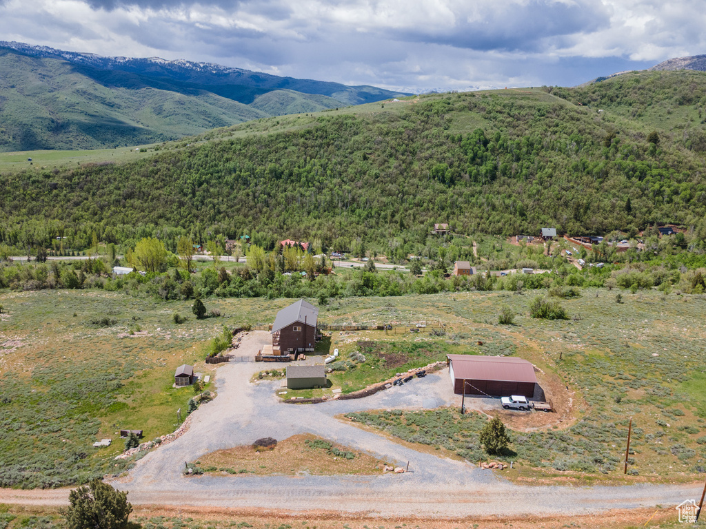 View of subject property featuring a mountainous background and a heavily wooded area