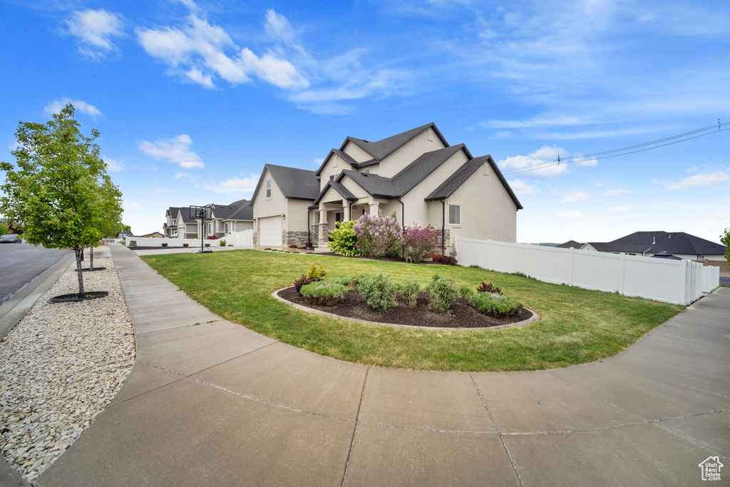 View of side of home with fence, stucco siding, and a yard
