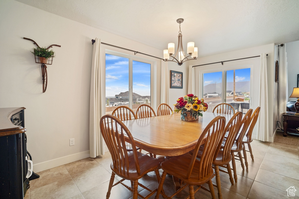 Dining area with an inviting chandelier, light tile patterned floors, and baseboards