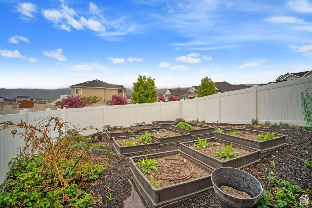 View of yard with a residential view, fence, and a garden