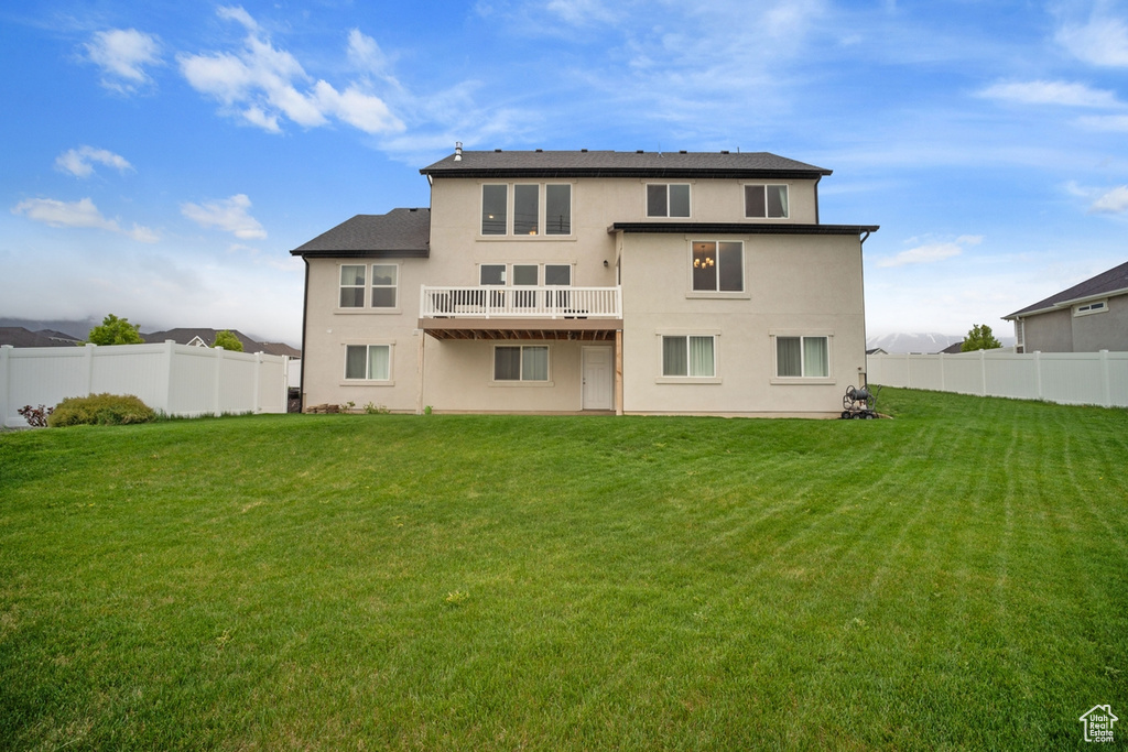 Back of house with a lawn, stucco siding, and a fenced backyard