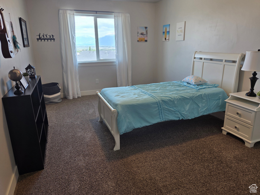Bedroom featuring dark colored carpet and baseboards