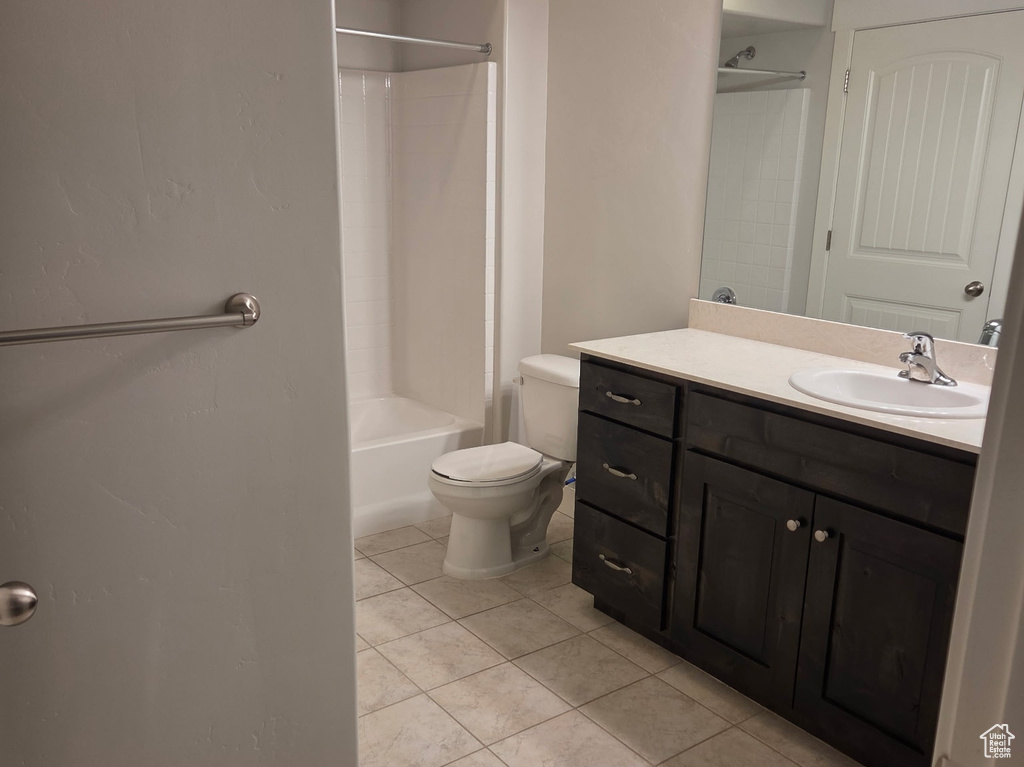 Bathroom featuring toilet, vanity, tile patterned floors, and shower / bathtub combination