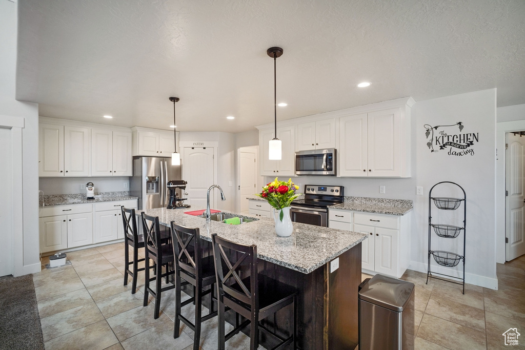 Kitchen with recessed lighting, a sink, white cabinets, and stainless steel appliances