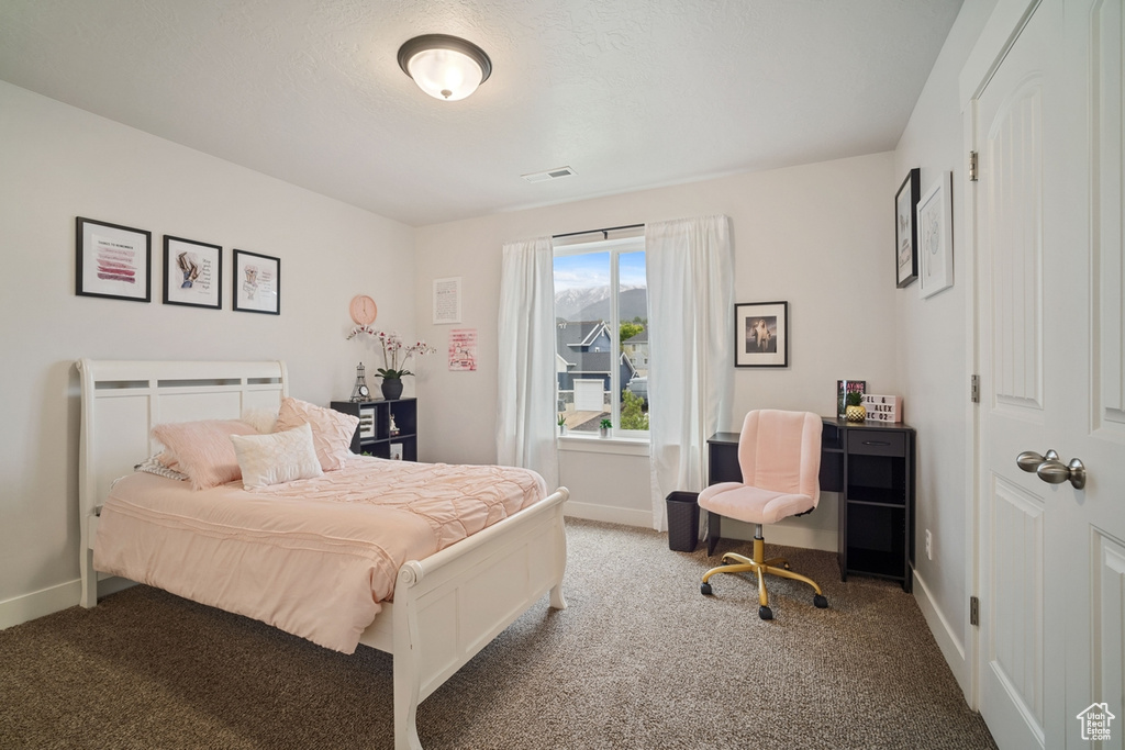 Carpeted bedroom with baseboards and visible vents