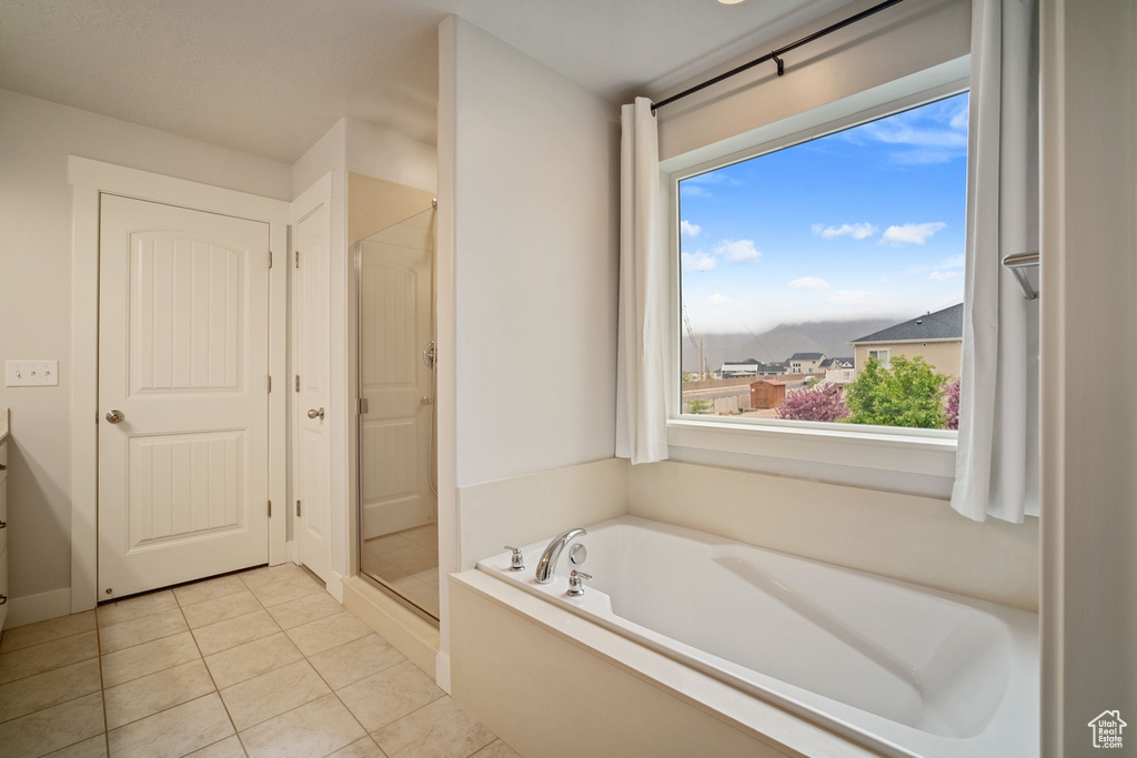 Bathroom with tile patterned floors, a shower stall, and a garden tub