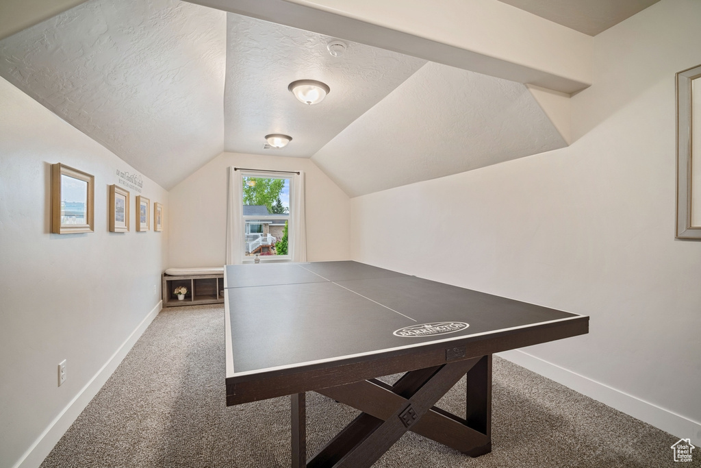 Game room with baseboards, a textured ceiling, carpet floors, and vaulted ceiling
