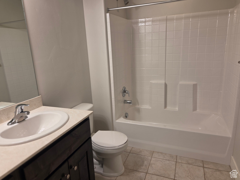 Full bathroom featuring toilet, tile patterned flooring, vanity, and bathtub / shower combination