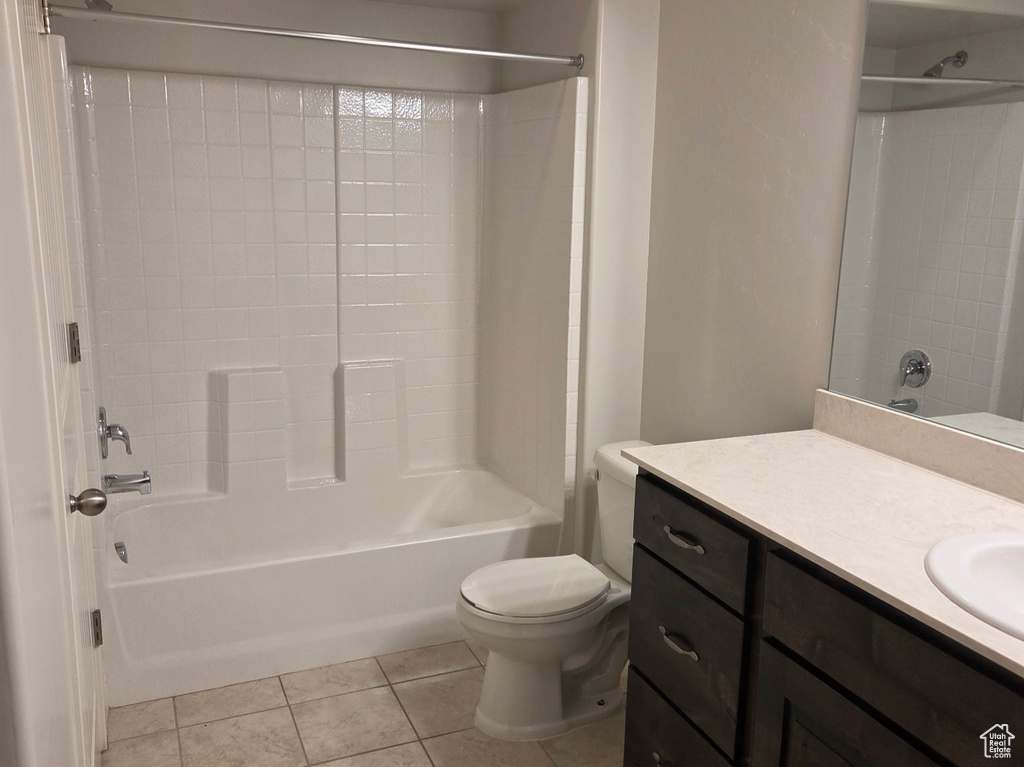Bathroom featuring toilet, vanity, shower / bathtub combination, tile patterned floors, and a textured ceiling