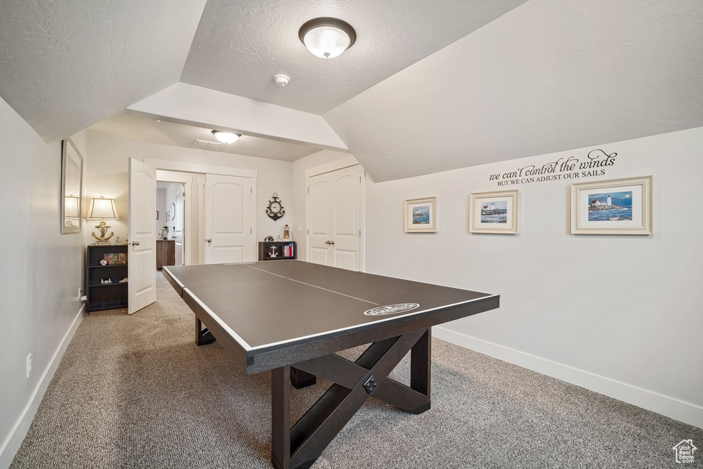 Playroom with baseboards, light carpet, and a textured ceiling
