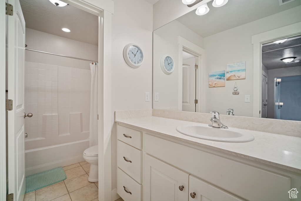 Full bathroom with shower / bath combo, tile patterned flooring, vanity, toilet, and visible vents