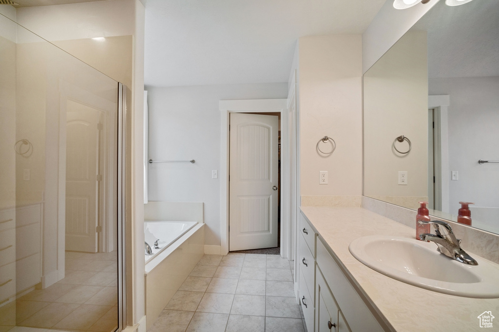 Full bathroom featuring vanity, a garden tub, and tile patterned floors