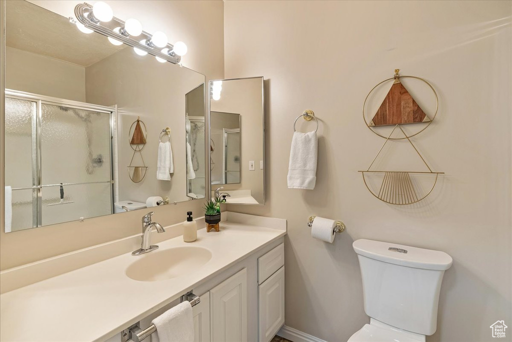 Full bathroom with a stall shower, vanity, and toilet