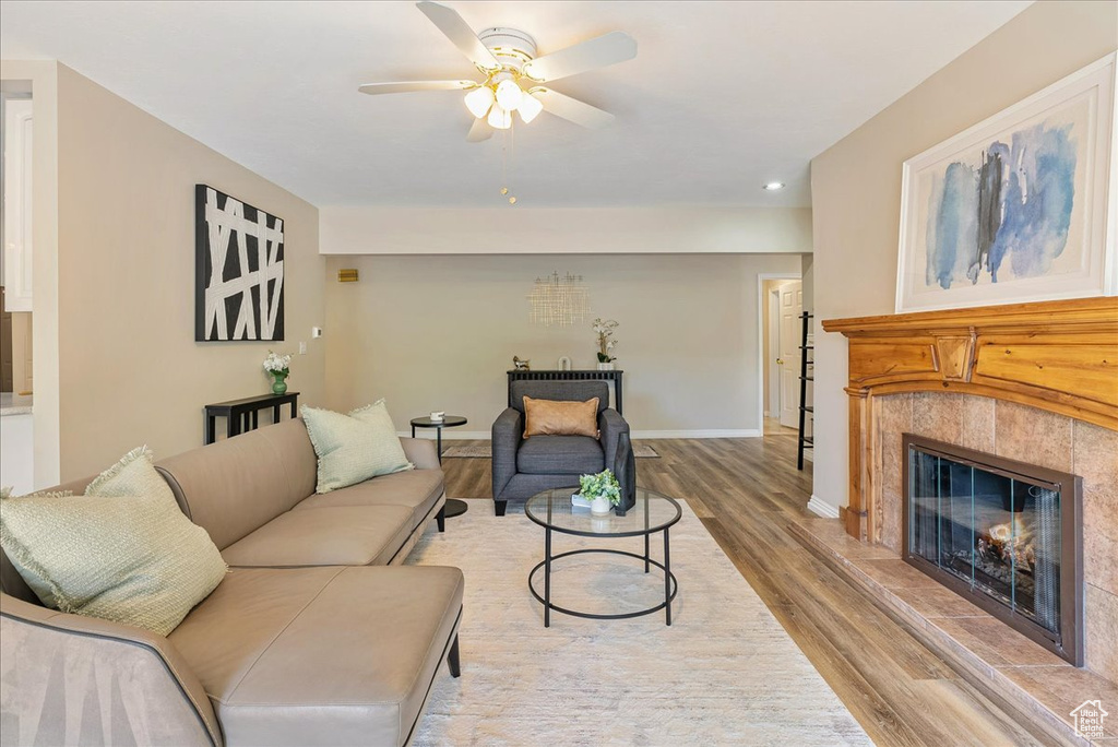 Living area featuring wood finished floors, recessed lighting, a fireplace, ceiling fan, and baseboards