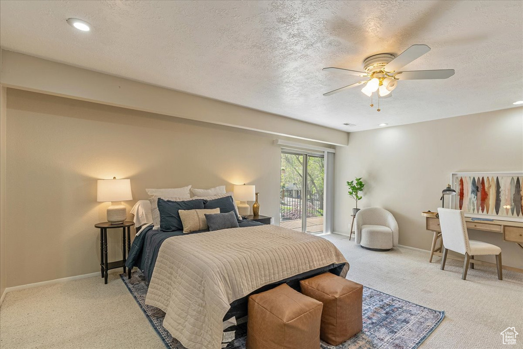 Bedroom with carpet, a textured ceiling, baseboards, ceiling fan, and access to outside