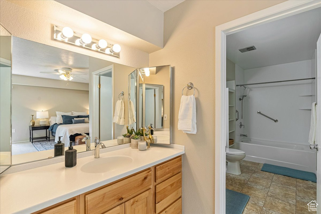 Ensuite bathroom featuring toilet, ensuite bathroom, vanity, visible vents, and a ceiling fan