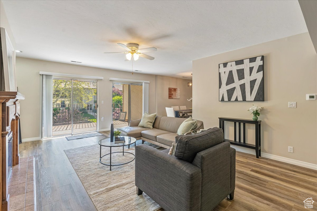 Living area featuring baseboards, a ceiling fan, and wood finished floors