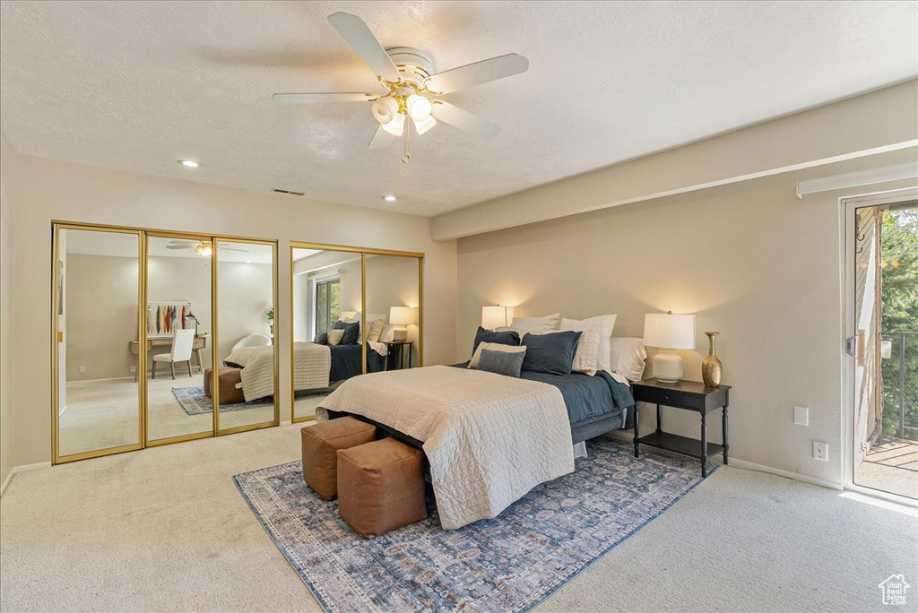Carpeted bedroom featuring baseboards, multiple closets, access to outside, and ceiling fan