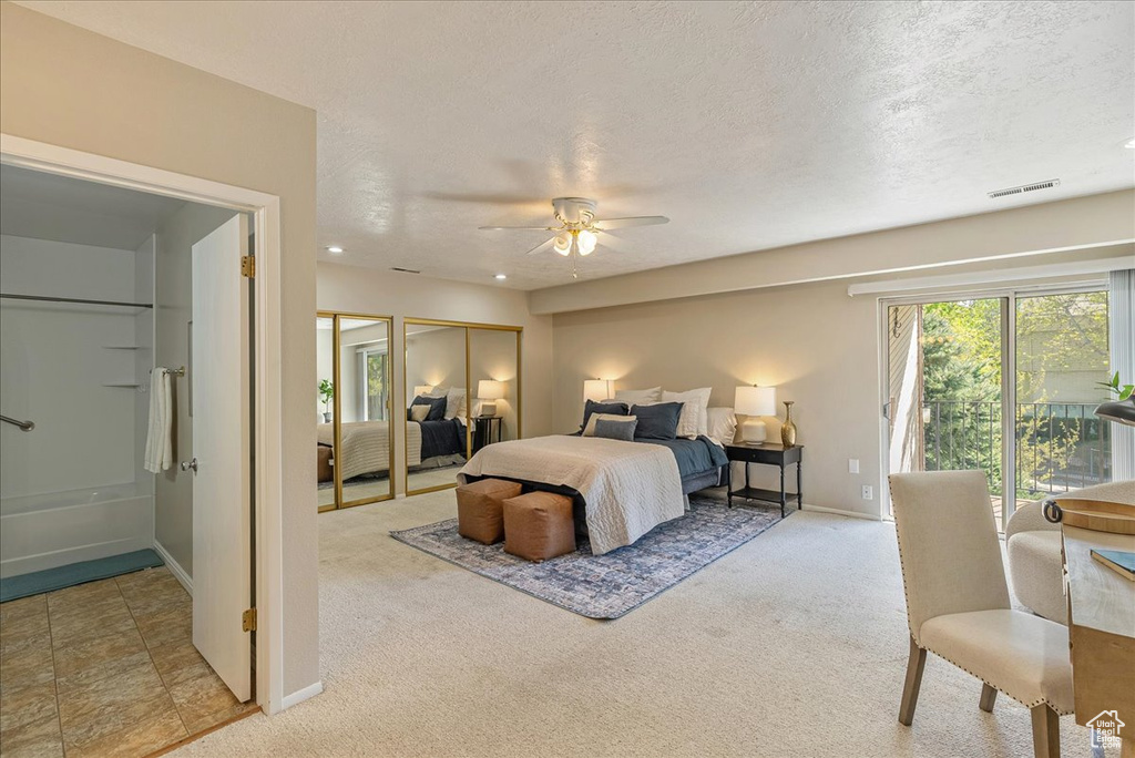 Bedroom with a textured ceiling, carpet, visible vents, baseboards, and access to exterior