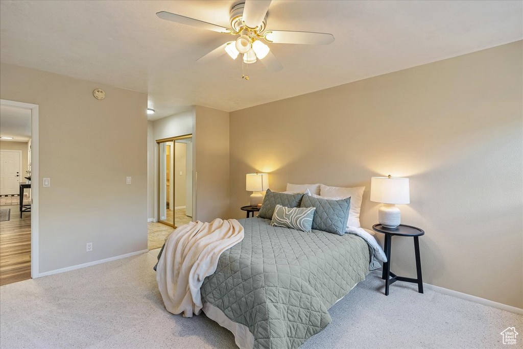 Carpeted bedroom with baseboards, a closet, and a ceiling fan
