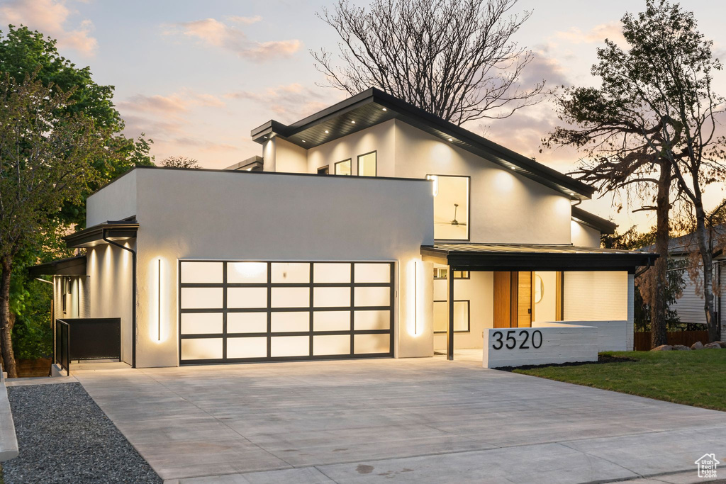 Contemporary home with driveway, stucco siding, and a garage