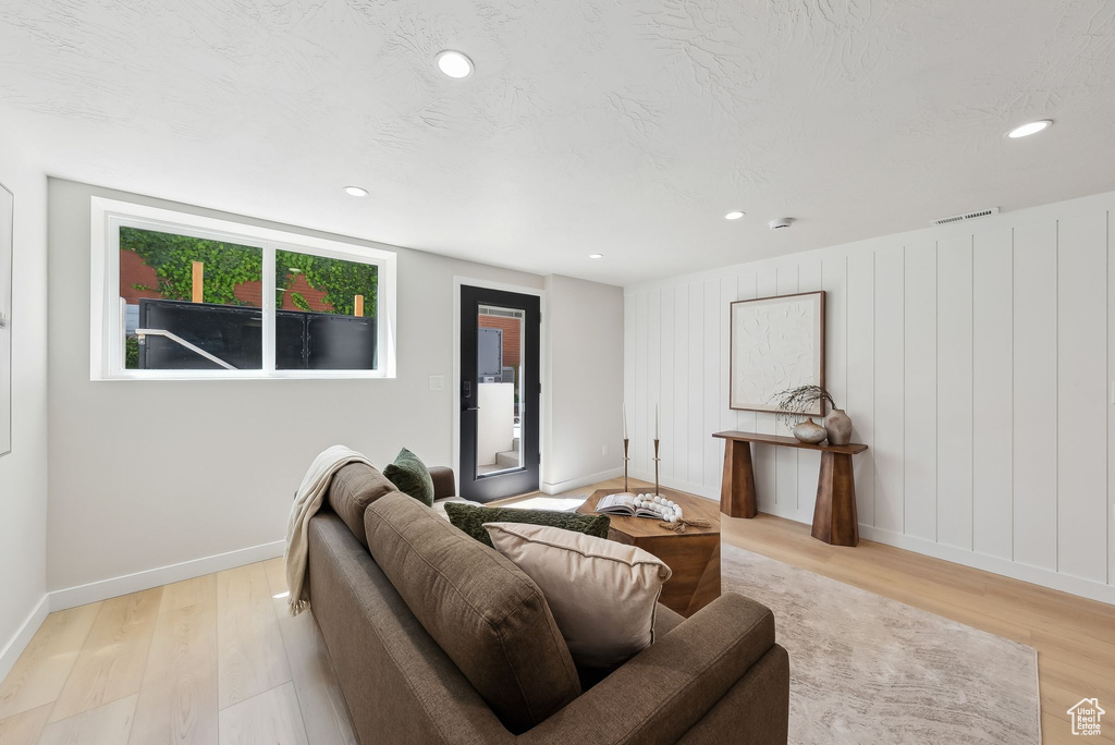 Living room with light wood-type flooring, baseboards, and recessed lighting