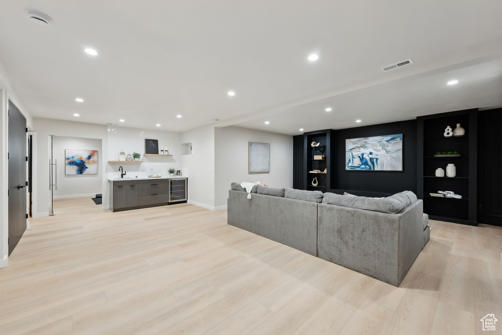 Living area with recessed lighting, beverage cooler, baseboards, light wood finished floors, and visible vents