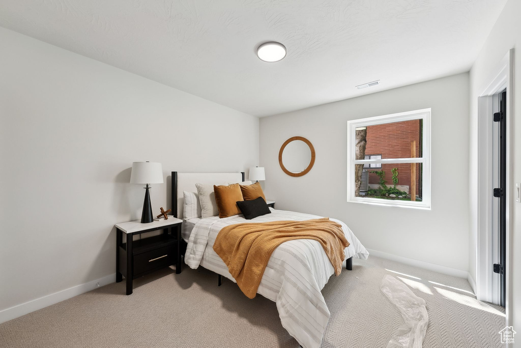 Bedroom featuring light carpet, baseboards, and visible vents