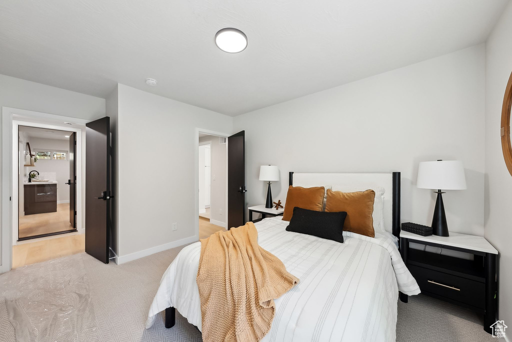 Bedroom featuring light colored carpet and baseboards