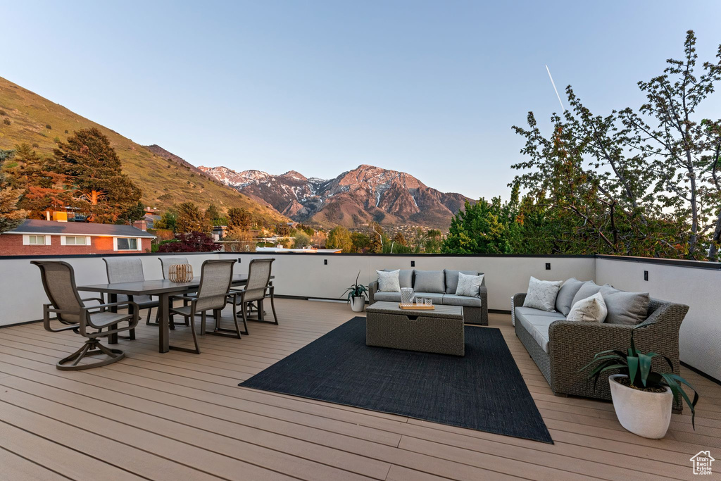 Wooden terrace featuring an outdoor living space, outdoor dining area, and a mountain view