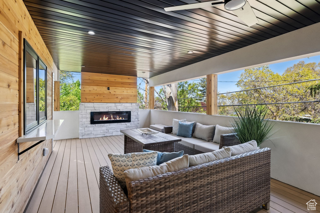 Wooden terrace featuring an outdoor living space with a fireplace