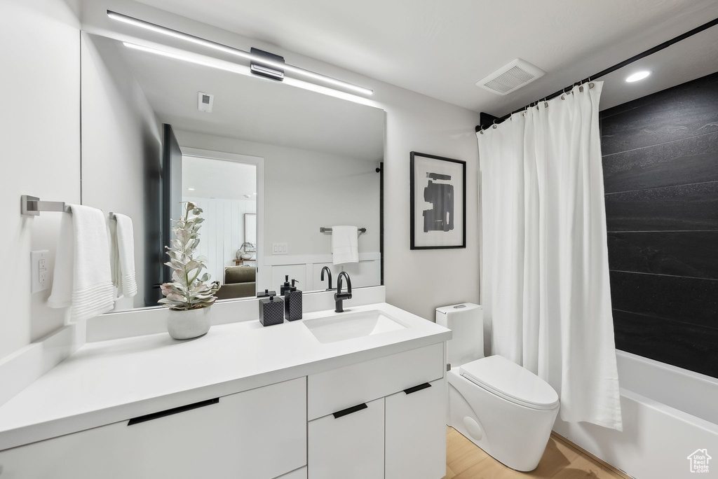 Full bathroom featuring recessed lighting, toilet, visible vents, vanity, and shower / bath combo