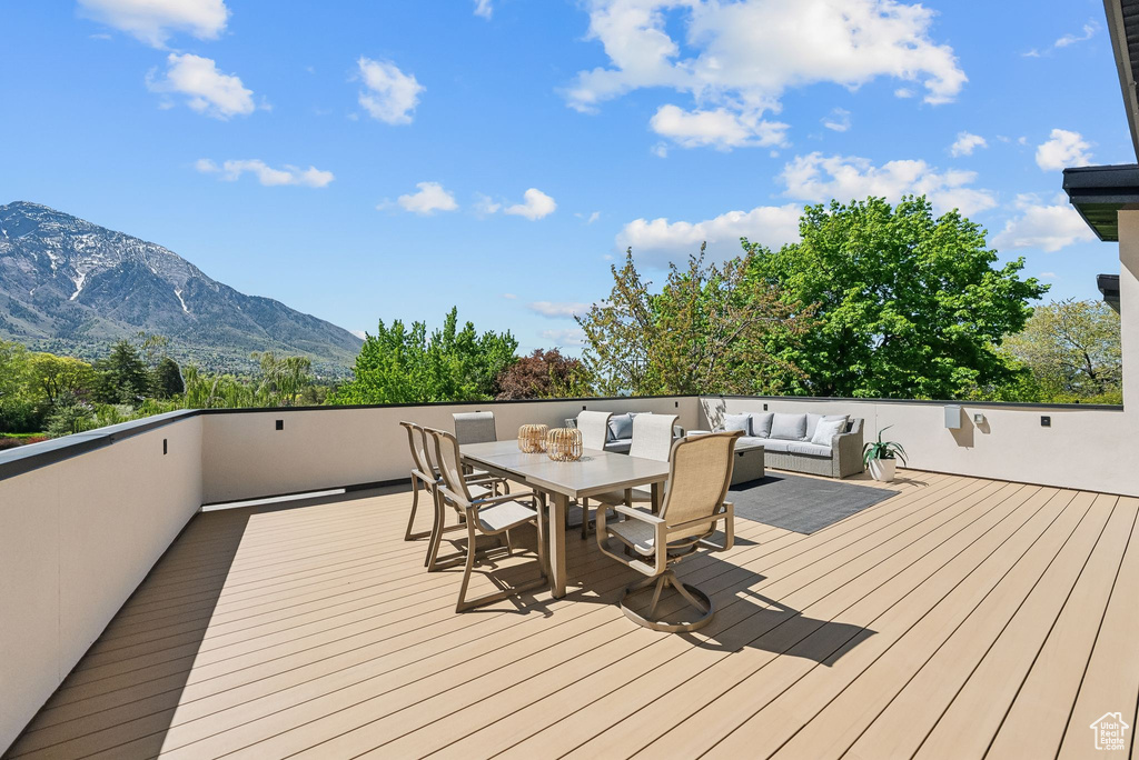 Wooden terrace with an outdoor hangout area, a mountain view, and outdoor dining area