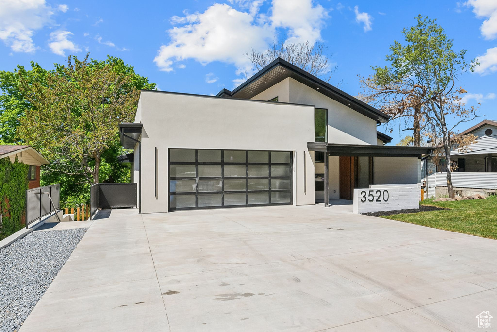 Contemporary house with an attached garage, stucco siding, and driveway