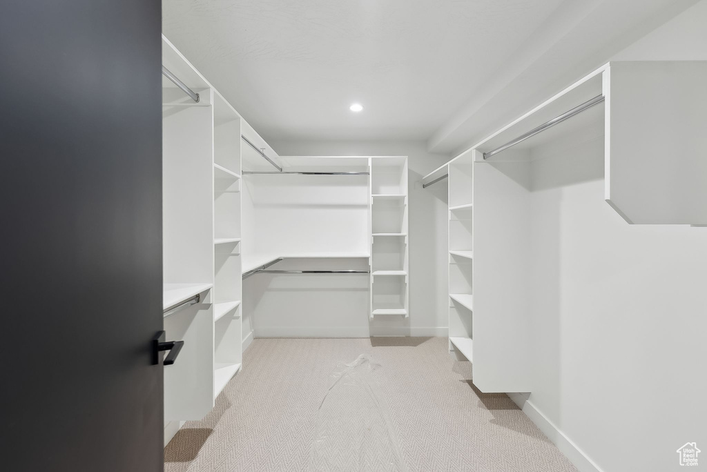Walk in closet featuring light colored carpet
