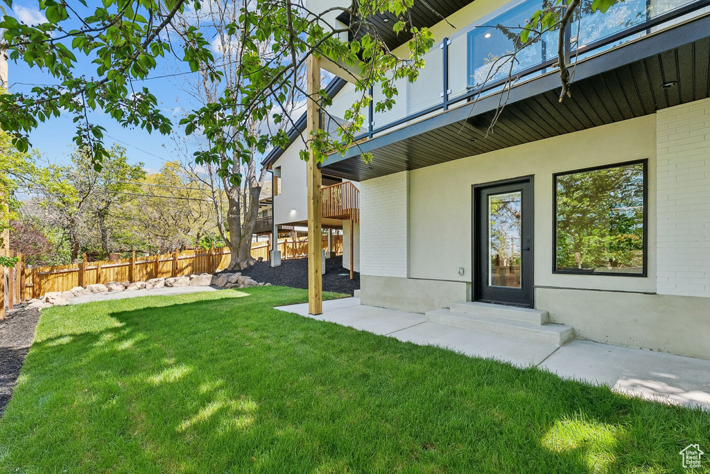 View of yard with a balcony and a fenced backyard