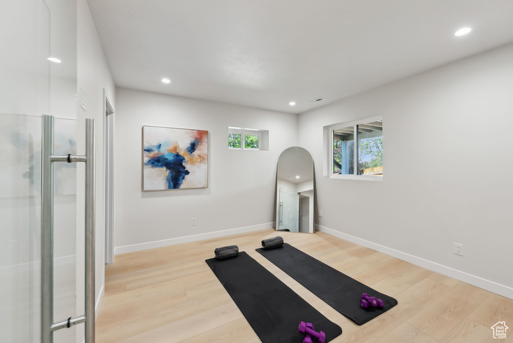 Exercise room featuring wood finished floors, baseboards, and recessed lighting
